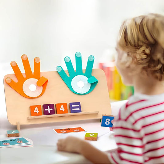 Kind spielt mit Montessori-Zählbrett aus Holz mit bunten Zahlen, Rechenzeichen und zwei magnetischen Händen zum Lernen von Plus- und Minusaufgaben.